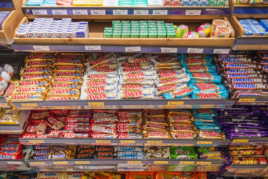 A supermarket shelf displays a variety of chocolate bars, including Twix, Kit Kat, Mars and other confectionery brands