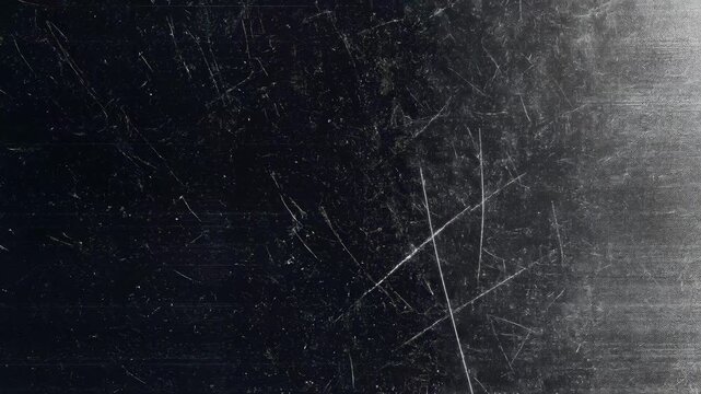 A scratched surface with a grayish texture, featuring subtle light reflections and a watermark.