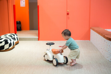 Baby playing happily at colorful playhouse indoors