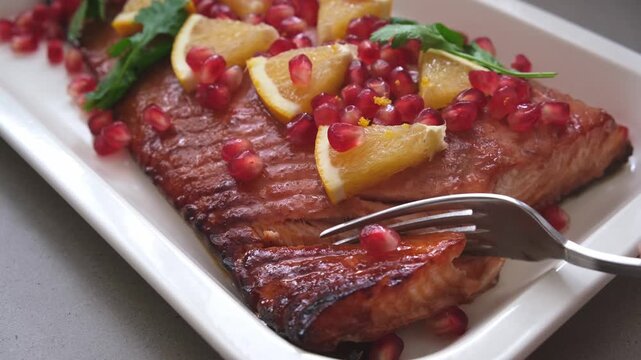 Christmas salmon cooking in pomegranate juice with orange and pomegranate seeds.