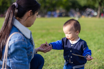 Happy baby playing with mother at park