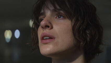 Young person with slightly messy hair looking up with a thoughtful expression