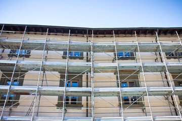 Metal scaffolding on a construction site built with prefabricated components to work safely on the facade of a building for the renovation of the plaster wall or realization of thermal insulation