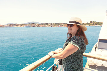 Woman in sunhat enjoying a summer ferry cruise to Corfu town.