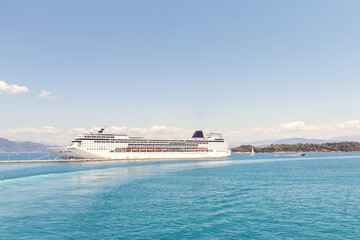 Large cruise ship docked at a pier on the turquoise sea