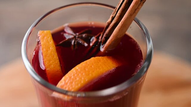 Mulled Wine with Orange and Cinnamon Sticks on wooden table. Close up