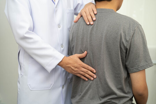 Physical therapy, Asian therapist doctor treat perform pain young man in hospital.