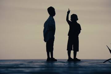 silhouette of a child walking on the beach at sunset
