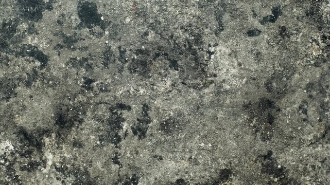 Closeup dirty ashtray bottom surface with dark burnt marks and textured gray ash residue background