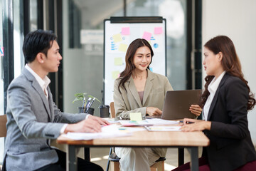 Group of Asian businesspeople sits down for a business investment planning meeting.	