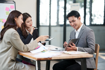Group of Asian businesspeople sits down for a business investment planning meeting.	