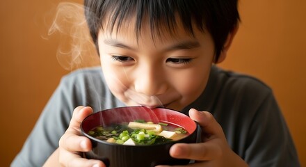 a young boy intently focuses on a steaming bowl of japanese miso soup enjoying the warm aroma and flavors within the dish high quality professional detailed