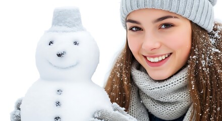 a smiling young woman with long brown hair and a gray knitted hat poses cheerfully with a small snowman in front of a white background
