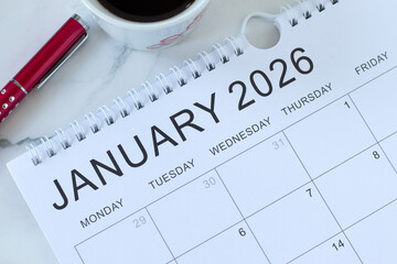 January 2026 calendar with pen and coffee cup. Top view.  Annual planning, business goals, weekly organizer concept.
