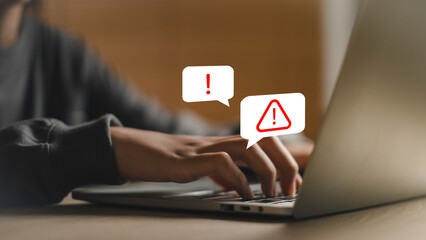 Hands typing on a laptop with digital warning icons, representing cybersecurity risks, data theft, phishing threats, and the importance of online safety awareness in the digital environment.