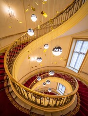 Elegant spiral staircase adorned with festive 2026 ornaments and shimmering confetti, perfect for New Year celebrations and milestone events in luxurious venues