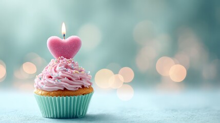 cupcake with heart-shaped candle, pastel green bokeh background 