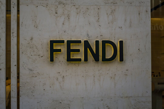 Vienna, Austria, Europe - Nov 08, 2025: the fendi luxury fashion store sign featuring glowing yellow black lettering against a rough travertine stone facade minimalist display of the brand name