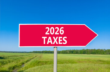 2026 taxes new year symbol. Concept words 2026 taxes on beautiful red road sign. Beautiful green grass field forest and blue sky background. Business and 2026 taxes new year concept. Copy space.