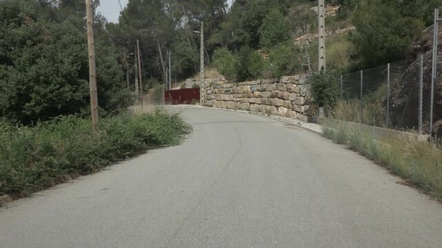 Road asphalt gimbal stabilized traveling Matadepera mountain village stone wall