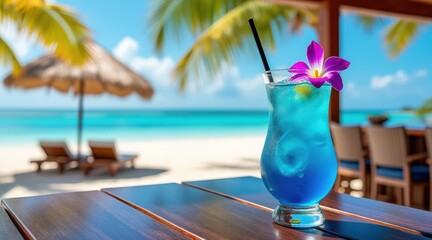 Blue tropical cocktail with orchid on wooden table, resort beach