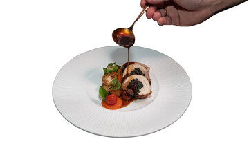 A chef delicately drizzling sauce onto a beautifully plated gourmet meal