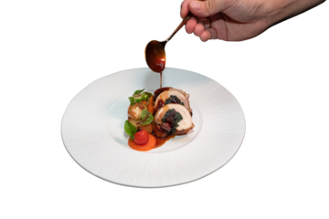 Close-up shot of chef carefully pouring sauce over a meticulously plated dish, showcasing culinary expertise and delicious food