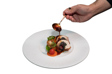 A chef expertly drizzles sauce over a beautifully plated gourmet dish