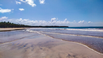 Blue waters shimmer under the fading sun at Cueira Beach on Boipeba Island, Bahia, Brazil.