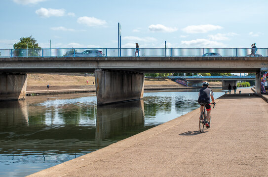  Exeter city centre canal path. A cyclist rides along the under pass of the road bridge in the city centre.