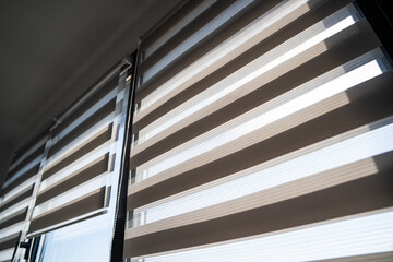 Modern zebra roller blinds with natural light filtering through striped window shades in an interior