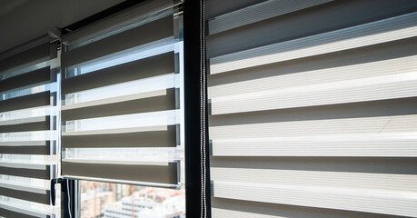 Striped zebra roller blinds on large windows providing adjustable light control in modern bright interior