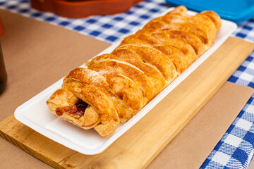 Gourmet savory sausage tarts, served as party appetizers on a wooden table.  Torta  salgadas gourmet de calabreza, servidas como aperitivos de festa sobre uma mesa de madeira. © Adriana Fotografias