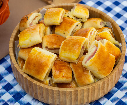 Mini p&atilde;es de padaria frescos e dourados em fundo neutro. Close-up of crispy golden mini breads on a neutral background.