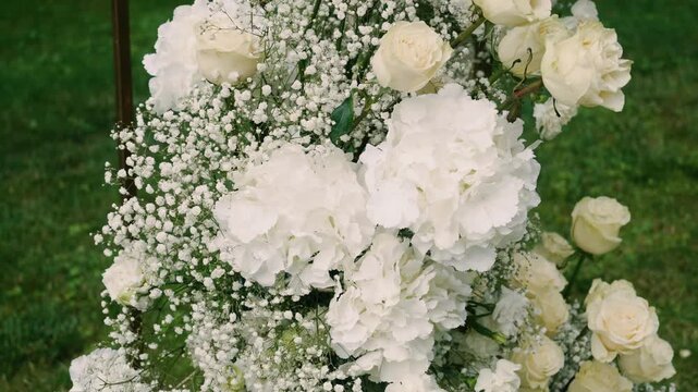 Beautiful white roses and eustoma flowers with petals and a romantic atmosphere. Outdoor wedding ceremony for the bride and groom. Decor and floristry.