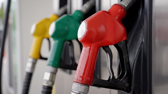 Color coded fuel pump nozzles at a modern gas station representing gasoline and diesel options for automotive refueling service