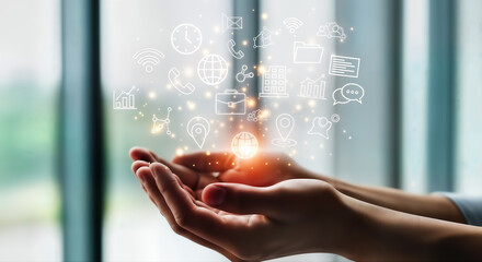 Hands presenting a glowing network of digital icons, illustrating concepts of global business, innovative technology, communication, and future solutions