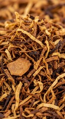 Dried shredded tobacco leaves form a textured background.