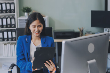 A smiling woman in a lab coat uses a tablet in a bright, modern environment.