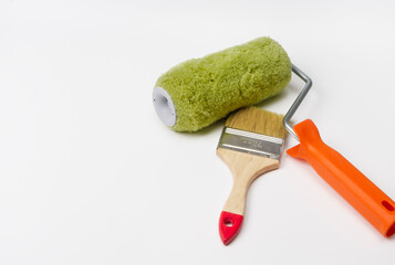 On a white background are tools for home or apartment renovation - a roller and a paint brush