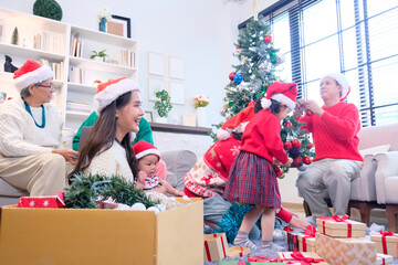 A young woman and her family smiling happily while celebrating Christmas or New Year.