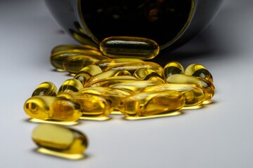 Geöffneter Behälter mit verstreuten Softgel-Kapseln