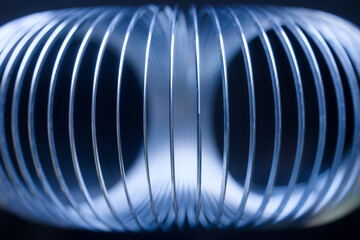 Abstract blue metal spring coil background. Futuristic concept of gravity field, wormhole tunnel, or sound wave volume technology. Photo