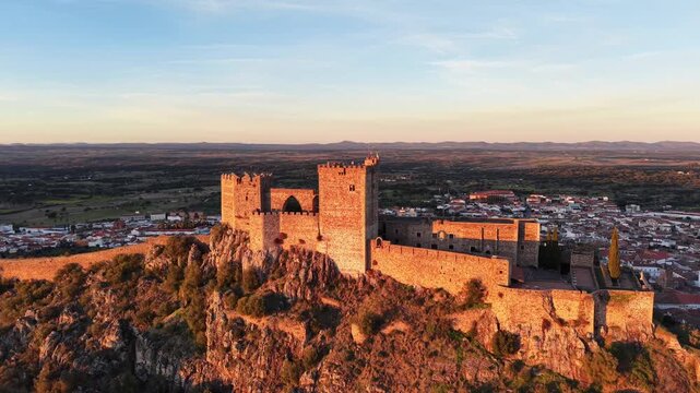 Fortaleza de Alburquerque en  secuencia de aproximaci&oacute;n a su torre principal ondeando sus banderas al aire del atardecer