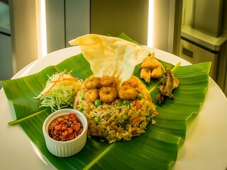 Illustration of delicious fried rice with shrimp served on banana leaf