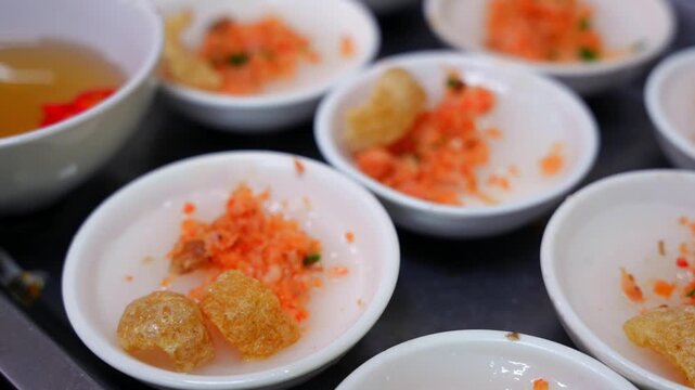 Small ceramic bowls of Banh Beo, steamed rice cakes topped with savory dried shrimp, crispy pork cracklings, and scallion oil.