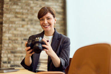 Professional Woman With Camera In Office Setting, Smiling And Ready To Shoot