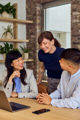 Asian Woman With Colleagues In Modern Office Discussing Projects And Smiles