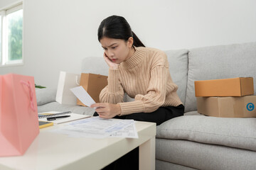 Stressed asian woman with large bills or invoices from shopping, no money to pay to expenses and credit card debt. shortage, Financial problems, mortgage, loan, poor, empty wallet, bankrupt