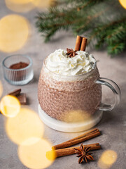 Hot chocolate with wipped cream in a cup on a light background with spices
